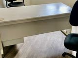 un bureau avec une chaise et une fenêtre dans un coin