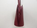 burgundy leather handbag hanging on a wall on a white wall