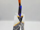 a glass sculpture with a knife sticking out of it ' s side