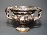 a large silver vase with two lions on it
