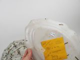 a person holding a white plate with a yellow sticker on it