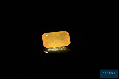 un gros plan d'un quartz jaune posé sur une surface noire