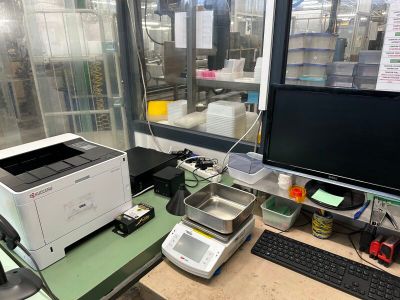 un ordinateur et une imprimante posés sur un bureau devant une grande fenêtre