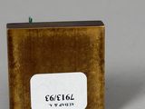 an image of a gold metal box with a white label on it