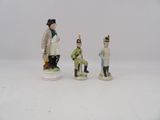 three figurines of men dressed in military uniforms and hats
