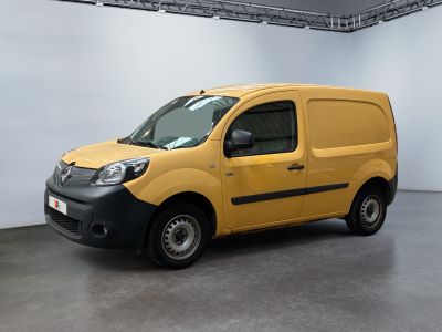 La camionnette jaune est garée dans une grande pièce aux murs blancs.