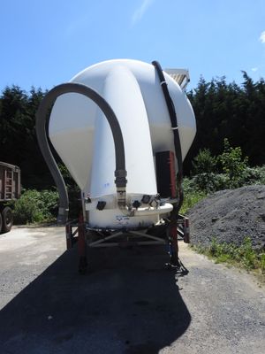un grand réservoir blanc posé à l'arrière d'un camion