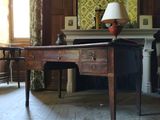 un bureau sur lequel est posée une lampe, dans une pièce