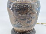 a blue and brown vase with a lamp on it