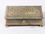 an old brass box with a design of animals on it