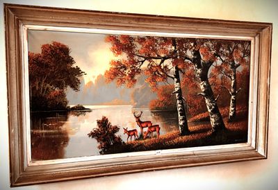 a picture of a painting of two deer by the water