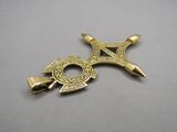 gold plated celtic cross pendant with two swords on a gray surface