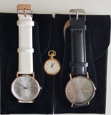 deux montres sont posées dans un écrin noir sur une surface blanche