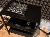 a table with a mixer and a chair in front of a sound wall