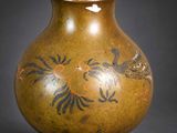 a brown vase with a bird design on it
