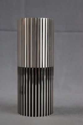 une image représentant un vase argenté et noir sur fond gris