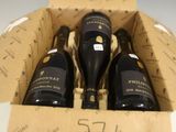 trois bouteilles de vin dans un carton sur une table