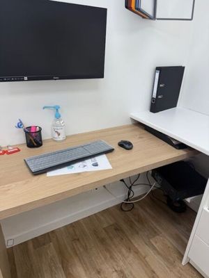 a computer desk with a monitor and keyboard on it