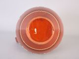 a brown and orange vase sitting on a white surface
