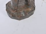 a statue of a man holding a dog on a rock