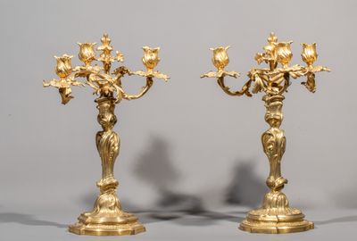 pair of antique brass candelabs with flowers on each of them