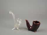 une pipe en verre et un vase en verre posés l'un à côté de l'autre
