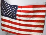 an old american flag hanging on a wall with a chain
