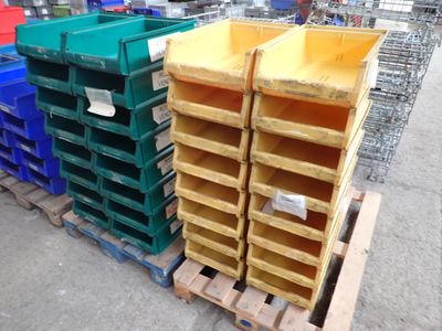 many different colored bins stacked on pallets in a warehouse