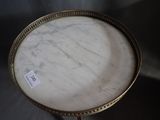 a white marble table with a gold base and a label on it