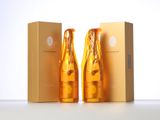two bottles of champagne sitting next to each other in front of a box