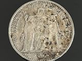une image représentant une pièce d'argent sur laquelle figurent un homme et une femme