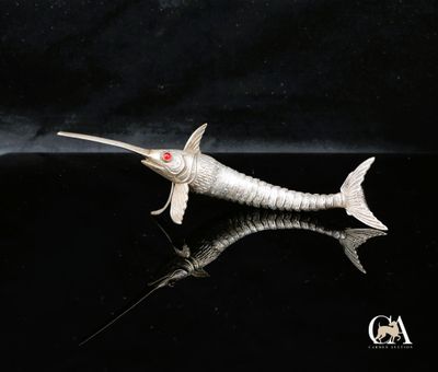 un poisson argenté posé sur une surface noire