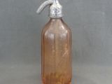 a brown glass bottle with a silver handle