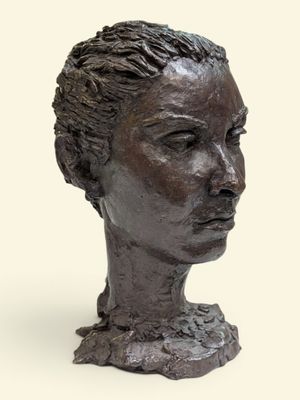 sculpture représentant la tête d'une femme sur un socle, sur fond blanc