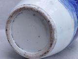 a blue and white vase sitting on a white surface