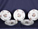 quatre assiettes ornées de motifs floraux sont posées sur une nappe bleue