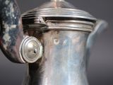 a close up of a silver coffee pot on a table