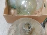 three empty glass bottles sitting in a box on the floor