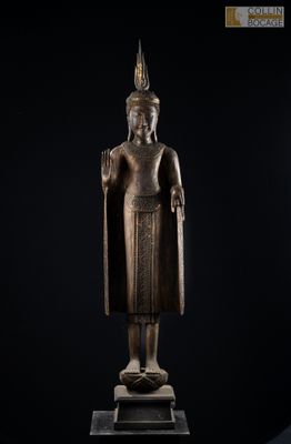une statue en bronze représentant une personne debout, coiffée d'une couronne