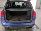 the back end of a blue car with its trunk open