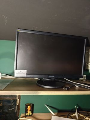 un écran d'ordinateur posé sur un bureau en bois
