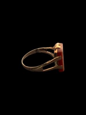 an image of a gold ring with a red stone in it