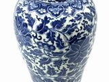 a blue and white vase sitting on a white surface