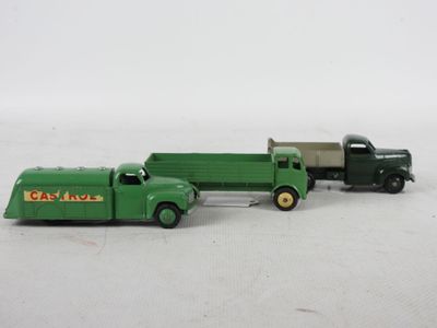 un petit camion vert et un autre petit camion vert posés sur une surface blanche
