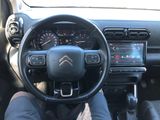 someone is sitting in the driver ' s seat of a car with their feet on the steering wheel