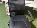 a black office chair that is sitting in front of a computer desk