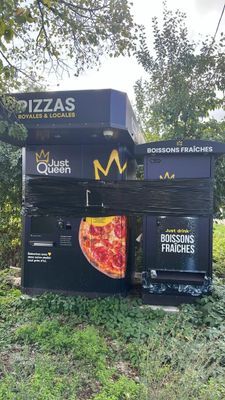 a vending machine that has a pizza on top of it