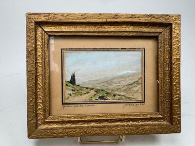 une peinture à l'huile représentant un paysage, dans un cadre doré, accrochée à un mur blanc