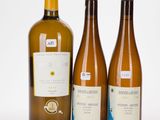 trois bouteilles de vin posées les unes à côté des autres sur une surface blanche