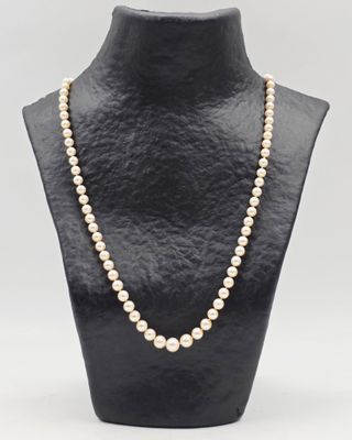 un collier de perles blanches sur un mannequin noir